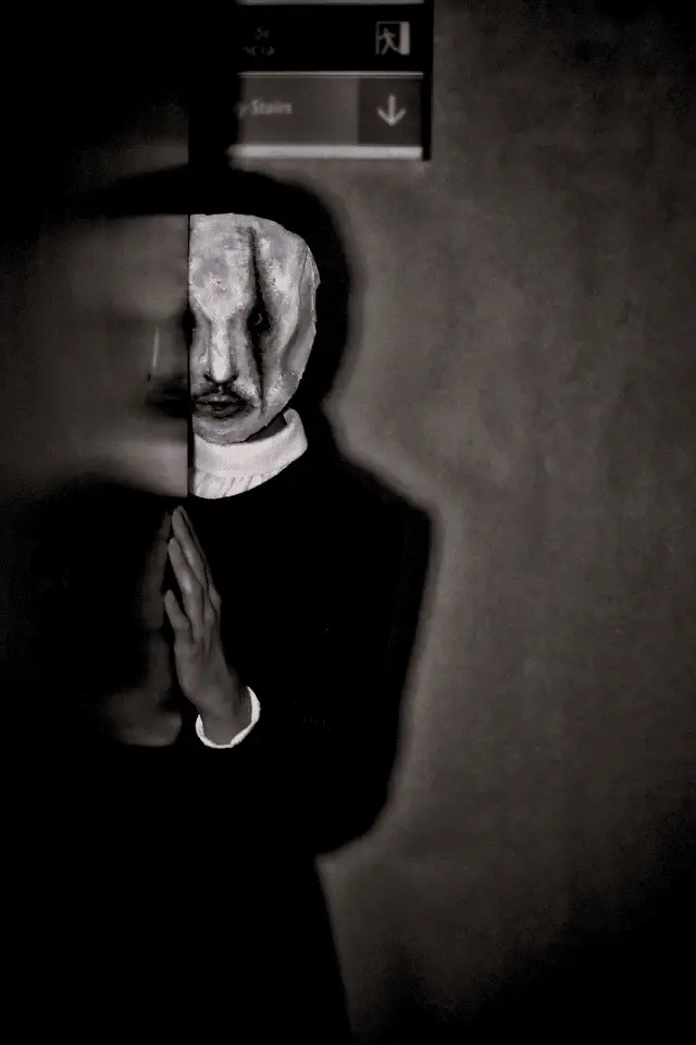 Fotografia in bianco e nero di Ricardo CL che rappresenta la paura attraverso una figura inquietante con un volto distorto e un'ombra minacciosa.