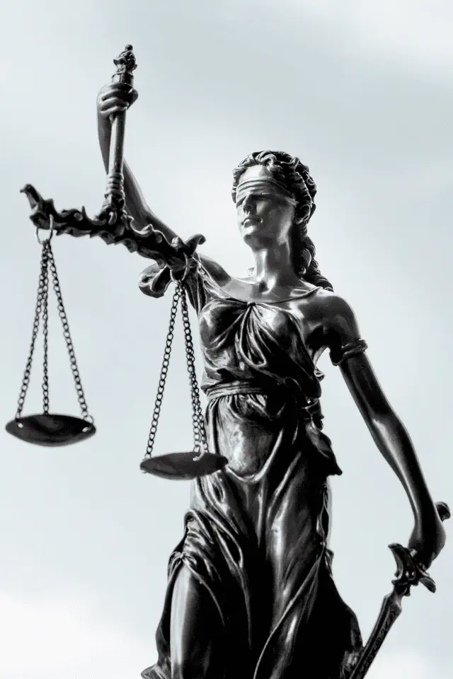 Statua della giustizia con bilancia e spada, occhi bendati simbolo di imparzialità.