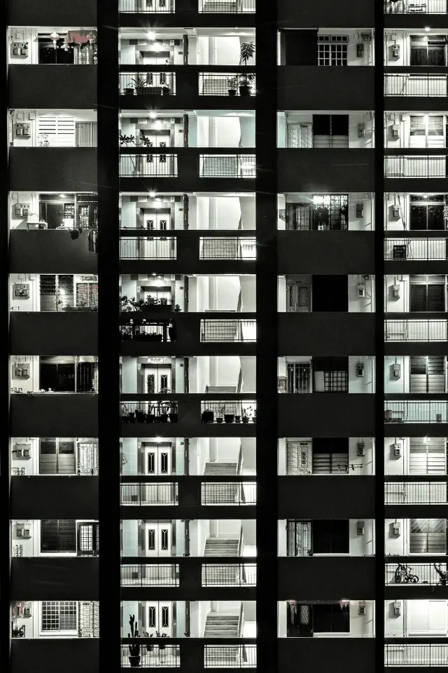 Facciata di un condominio illuminato di notte, simbolo del coabitare tra persone e dentro se stessi.